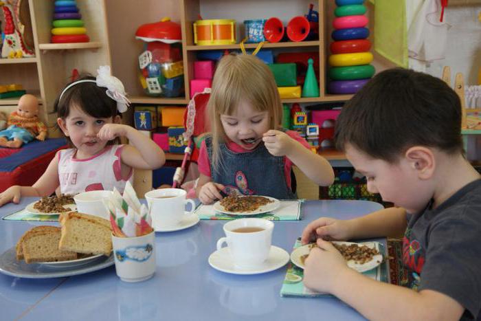 Помічник вихователя розставляє тарілки і прилади таким чином, щоб малюки не заважали один одному під час споживання їжі